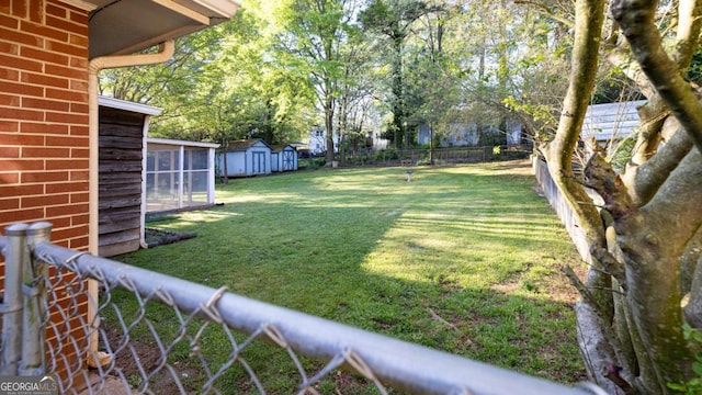 view of yard featuring an outbuilding, a shed, and fence private yard