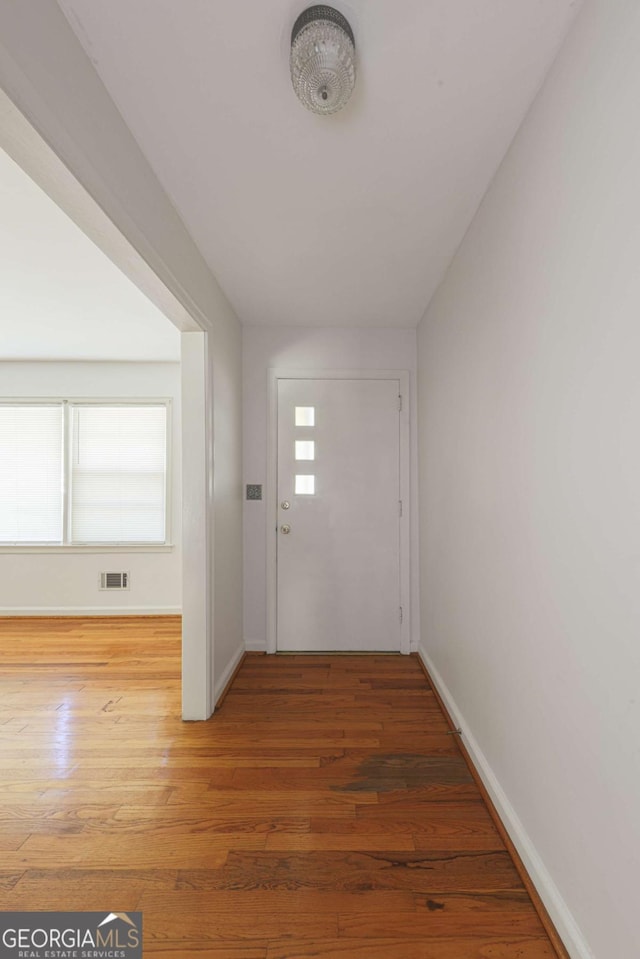 entryway featuring visible vents, baseboards, and wood finished floors