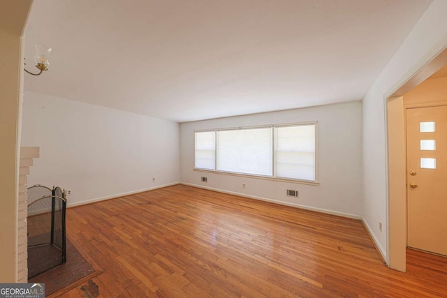 unfurnished living room with visible vents, baseboards, and light wood-type flooring