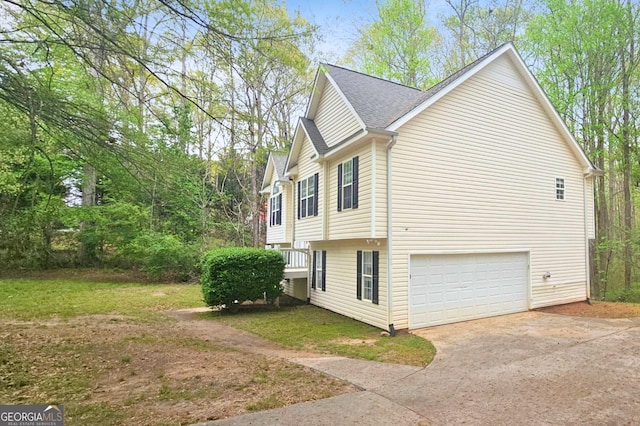 28 Willow Ridge Dr, Hampton, GA 30228 - view of side of property with a shingled roof, driveway, a garage, and a lawn