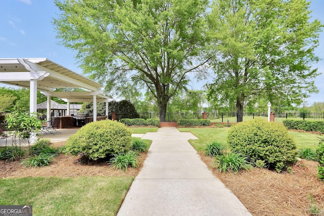 view of community with a patio, a yard, and fence