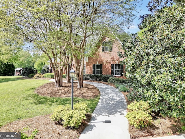 view of property hidden behind natural elements featuring a front lawn