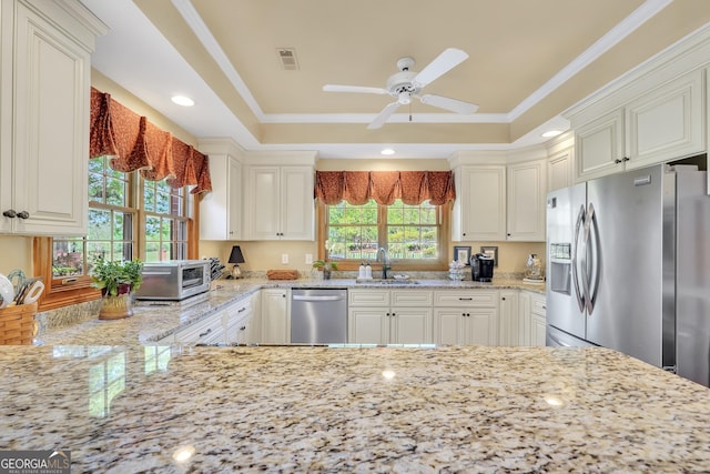 kitchen featuring a ceiling fan, light stone countertops, visible vents, appliances with stainless steel finishes, and a sink