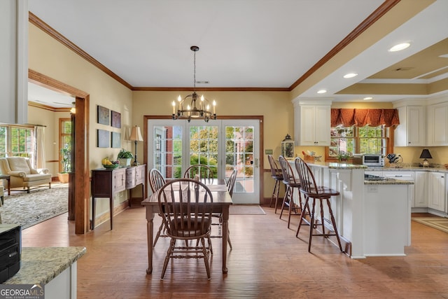 dining space featuring baseboards, a notable chandelier, ornamental molding, light wood-type flooring, and recessed lighting