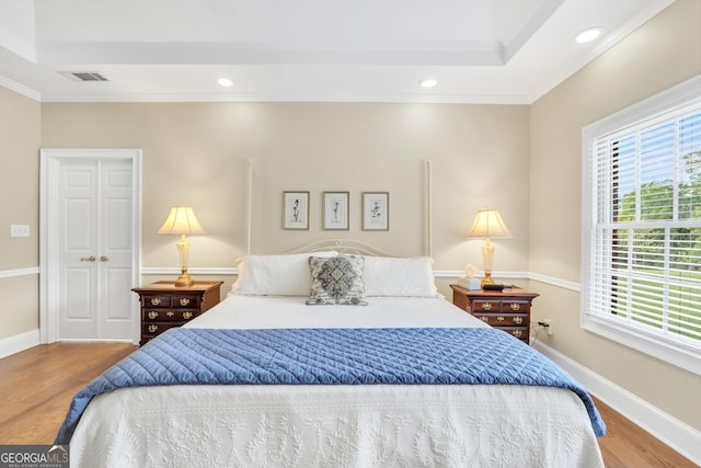 bedroom featuring recessed lighting, visible vents, crown molding, and wood finished floors