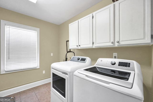 washroom with cabinet space, light tile patterned floors, washer and clothes dryer, and baseboards