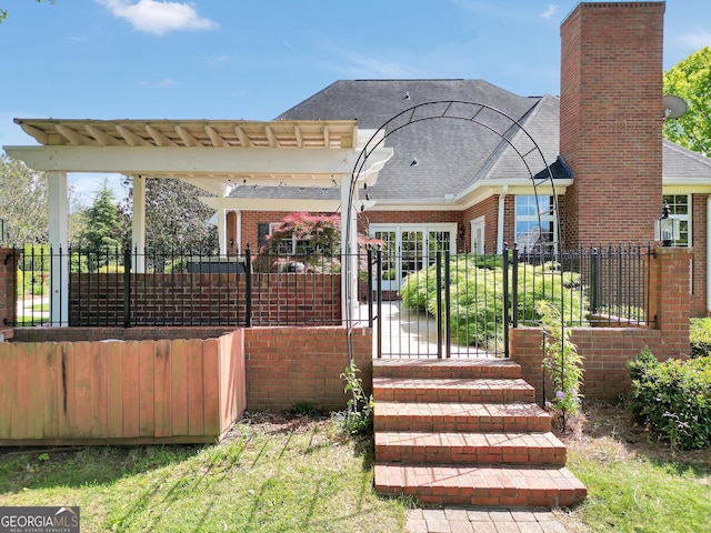 back of property featuring a chimney, a shingled roof, fence, and brick siding