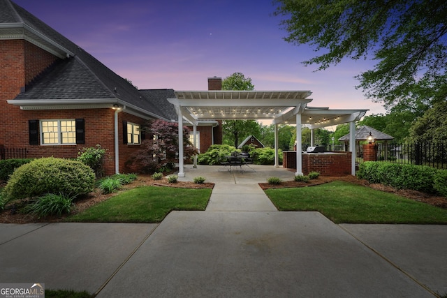 view of front facade featuring a pergola, exterior kitchen, fence, a patio, and brick siding