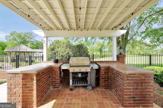 view of patio / terrace featuring grilling area, an outdoor kitchen, and a fenced backyard