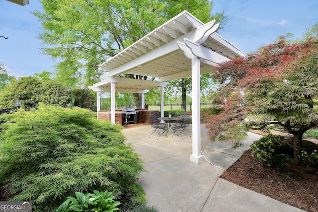 view of patio featuring grilling area, an outdoor kitchen, and fence