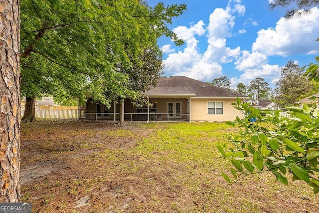 145 Spring Lake Cir, Brunswick, GA 31525 - rear view of house with fence, a sunroom, and stucco siding