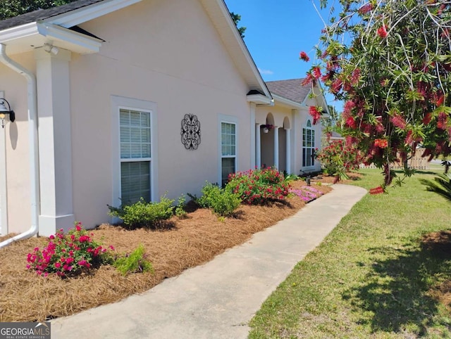 145 Spring Lake Cir, Brunswick, GA 31525 - exterior space featuring a yard, a shingled roof, and stucco siding