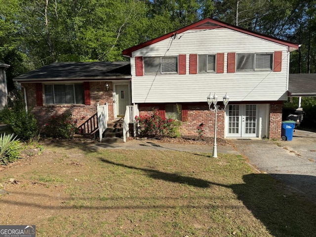 6695 Cedar Hurst Trl, Atlanta, GA 30349 - tri-level home featuring french doors, a front lawn, and brick siding