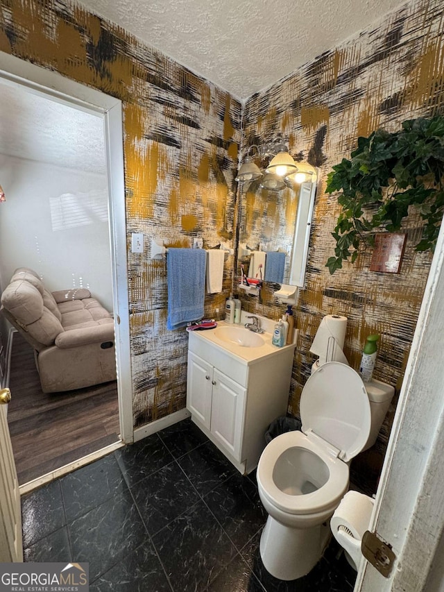 6695 Cedar Hurst Trl, Atlanta, GA 30349 - bathroom featuring a textured ceiling, vanity, toilet, marble finish floor, and baseboards