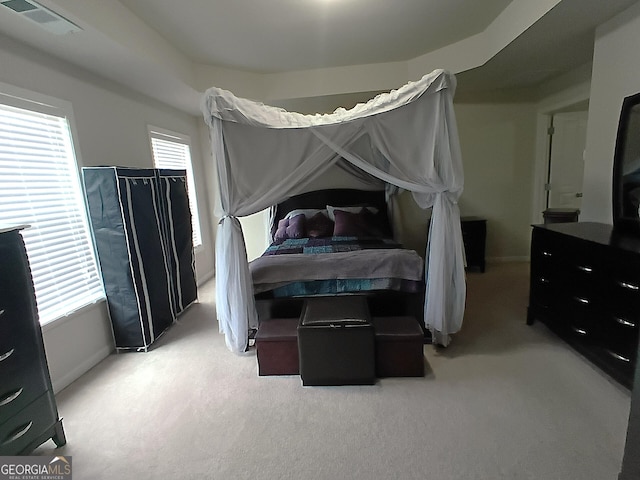 bedroom with visible vents, baseboards, and light carpet
