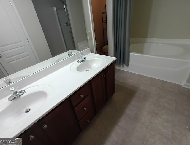 bathroom featuring a sink, toilet, and double vanity