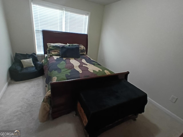 bedroom with baseboards and carpet