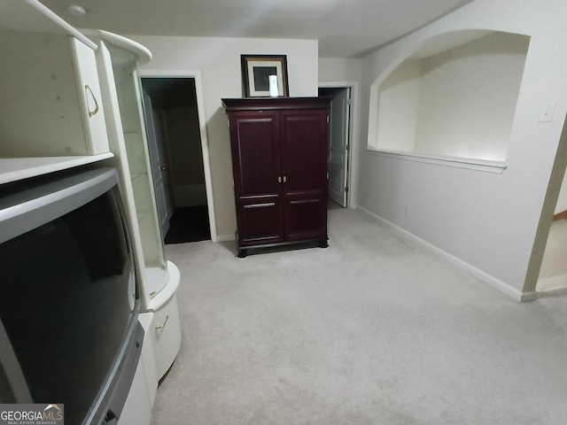 interior space with light carpet and baseboards