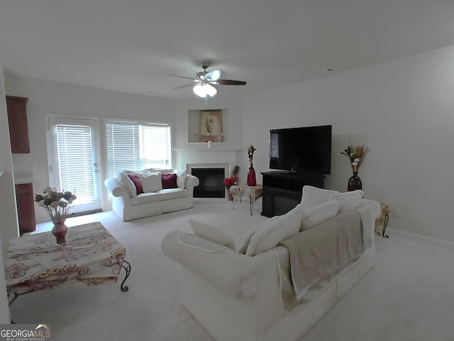 living room with ceiling fan, carpet flooring, and a fireplace