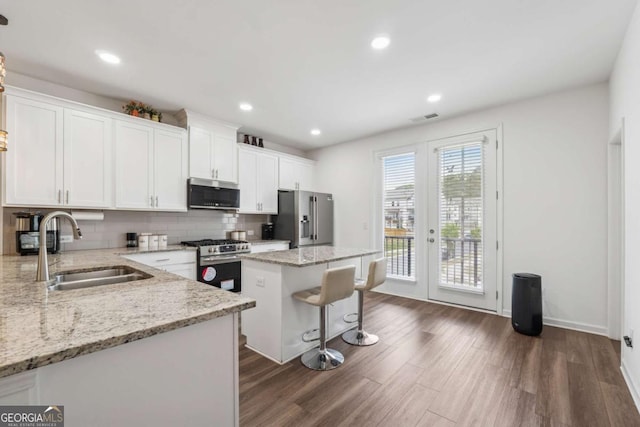 kitchen with visible vents, a sink, appliances with stainless steel finishes, dark wood-style floors, and white cabinetry