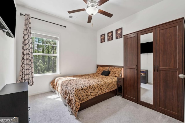 bedroom featuring ceiling fan, light carpet, visible vents, and baseboards