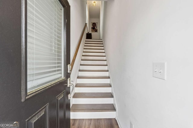 stairway featuring baseboards and wood finished floors