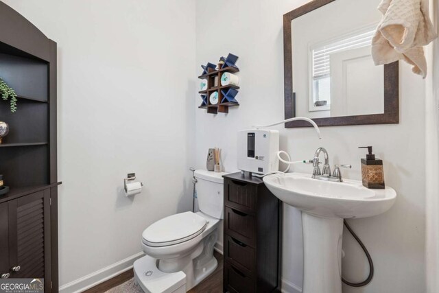 bathroom with toilet and baseboards