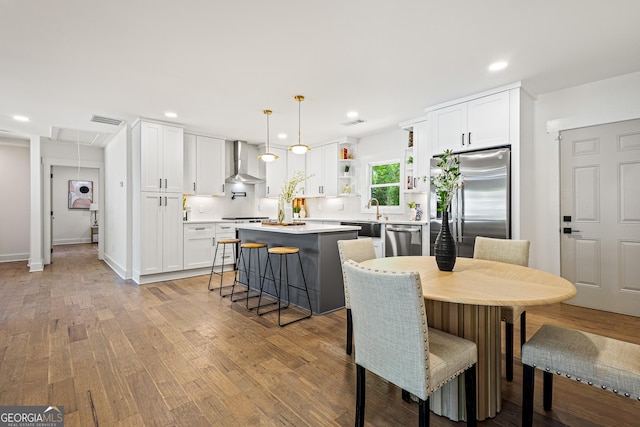 dining room featuring attic access, light wood-type flooring, visible vents, and recessed lighting