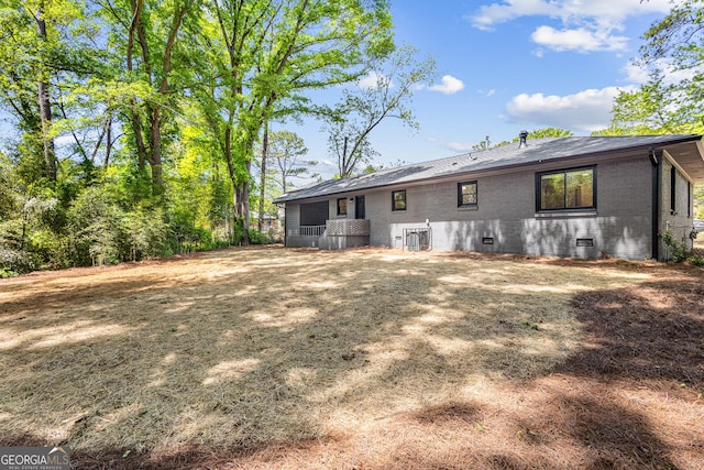 back of property with brick siding and crawl space