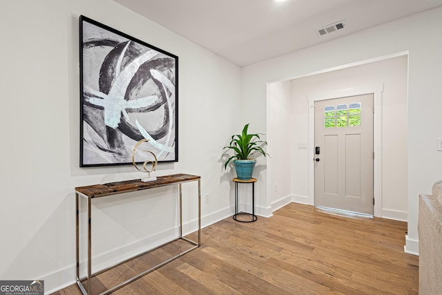 entryway featuring baseboards, wood finished floors, and visible vents