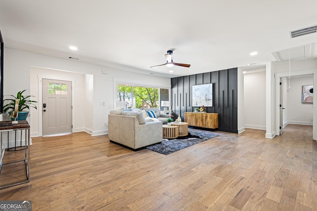 living area with attic access, ceiling fan, visible vents, and light wood-style flooring