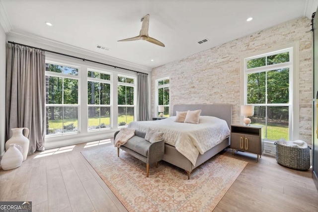 bedroom with hardwood / wood-style floors, visible vents, and multiple windows