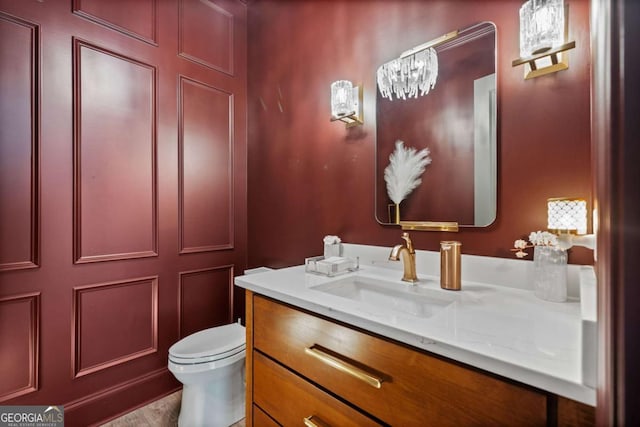 half bath featuring vanity and toilet
