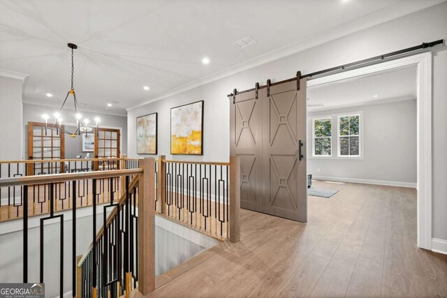 1472 Grizzle Rd, Dawsonville, GA 30534 - corridor featuring a barn door, crown molding, a chandelier, an upstairs landing, and wood finished floors