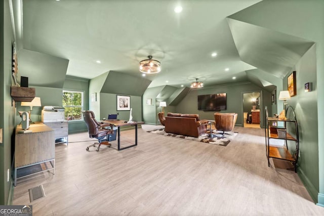 interior space featuring baseboards, visible vents, wood finished floors, and lofted ceiling