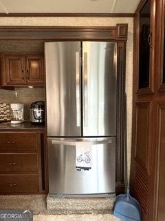 details with tasteful backsplash, freestanding refrigerator, and dark countertops