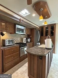 kitchen featuring tasteful backsplash, dark countertops, a toaster, and stainless steel appliances