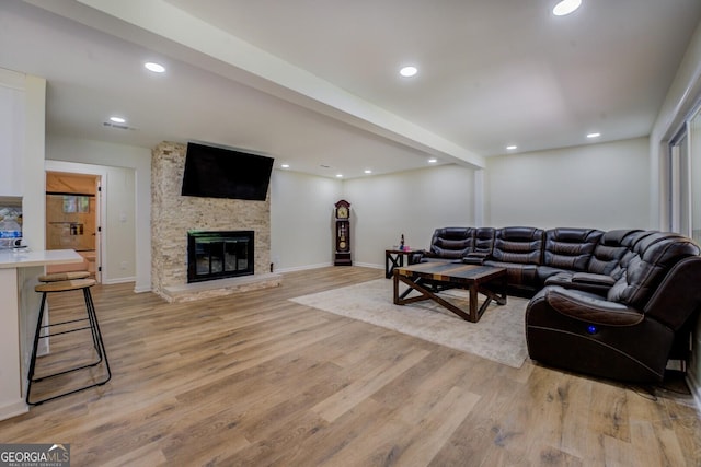living room featuring a fireplace, recessed lighting, visible vents, and light wood-style floors