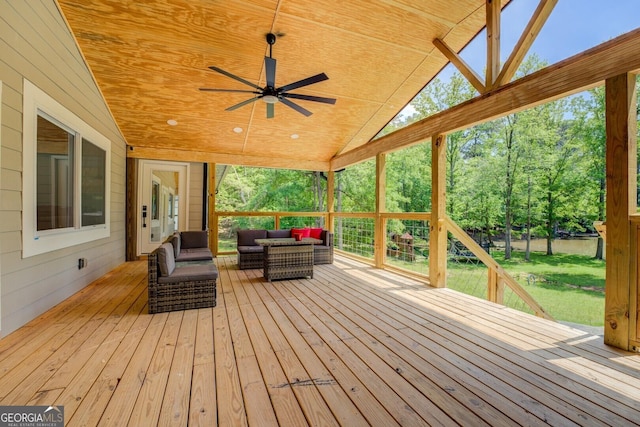 deck with an outdoor living space, a ceiling fan, and a yard