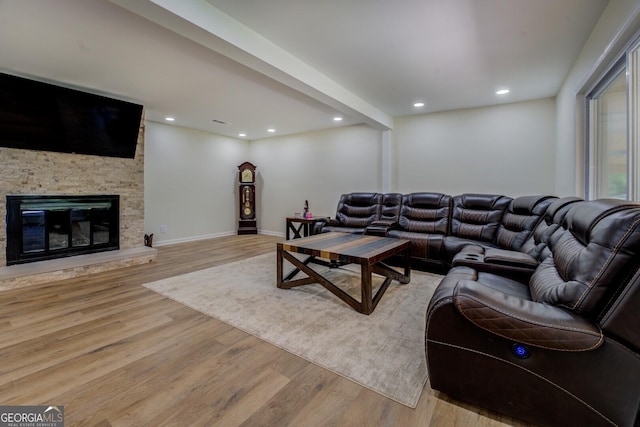 living area with light wood-style floors, baseboards, a fireplace, and recessed lighting
