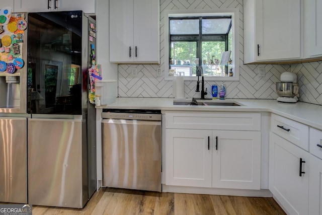 kitchen featuring a sink, appliances with stainless steel finishes, white cabinets, and light countertops