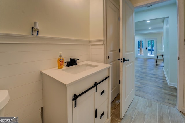 bathroom featuring vanity, french doors, recessed lighting, and wood finished floors