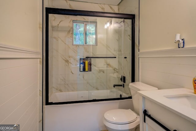bathroom featuring vanity, enclosed tub / shower combo, and toilet
