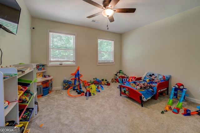 recreation room featuring ceiling fan, visible vents, baseboards, and carpet