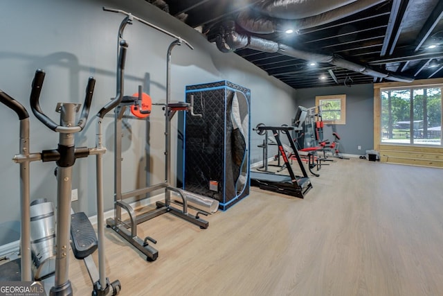 workout room featuring baseboards and wood finished floors
