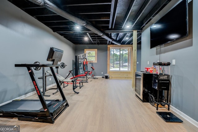 exercise room featuring baseboards and wood finished floors