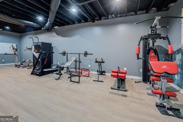 workout room with baseboards and wood finished floors
