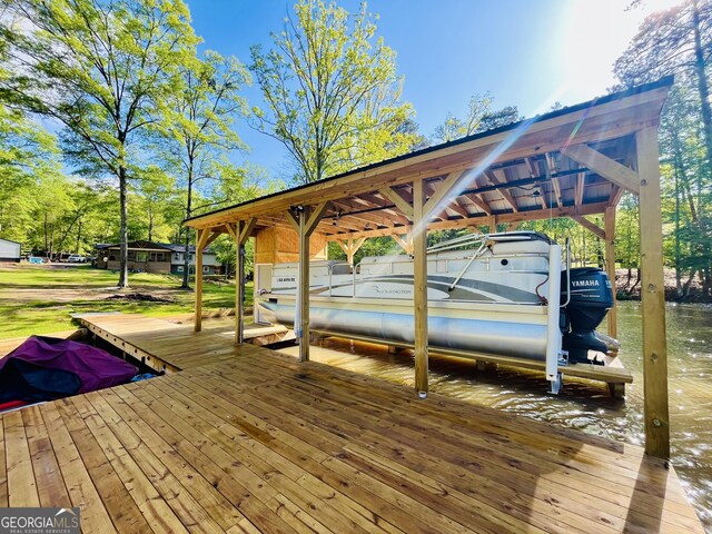 dock area with boat lift and a water view