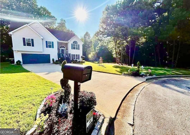 split foyer home with concrete driveway, a front lawn, and an attached garage