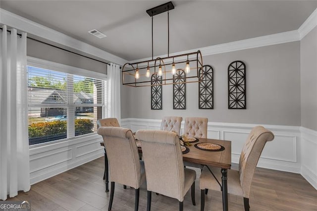 dining room featuring wainscoting, visible vents, ornamental molding, and dark wood-style floors